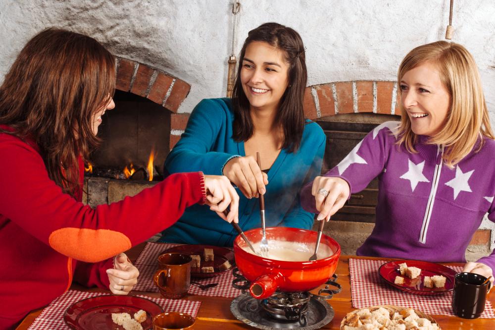 Young women eating cheese fondue