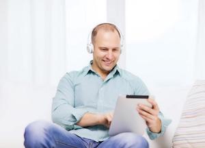 smiling man with tablet and earphone