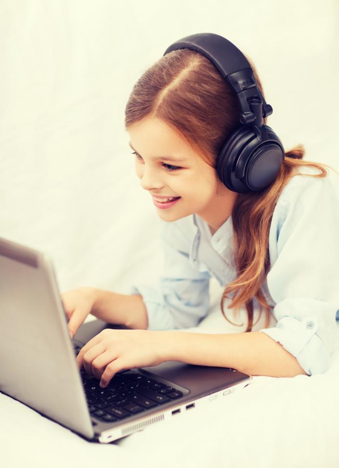 smiling girl on laptop with earphones 