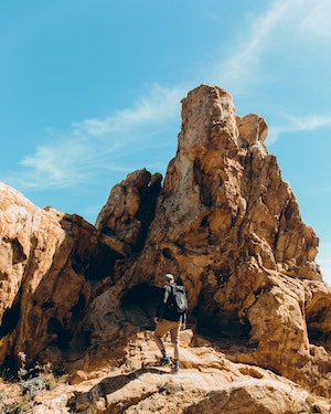 Backpacker hiking uo a rocky mountain