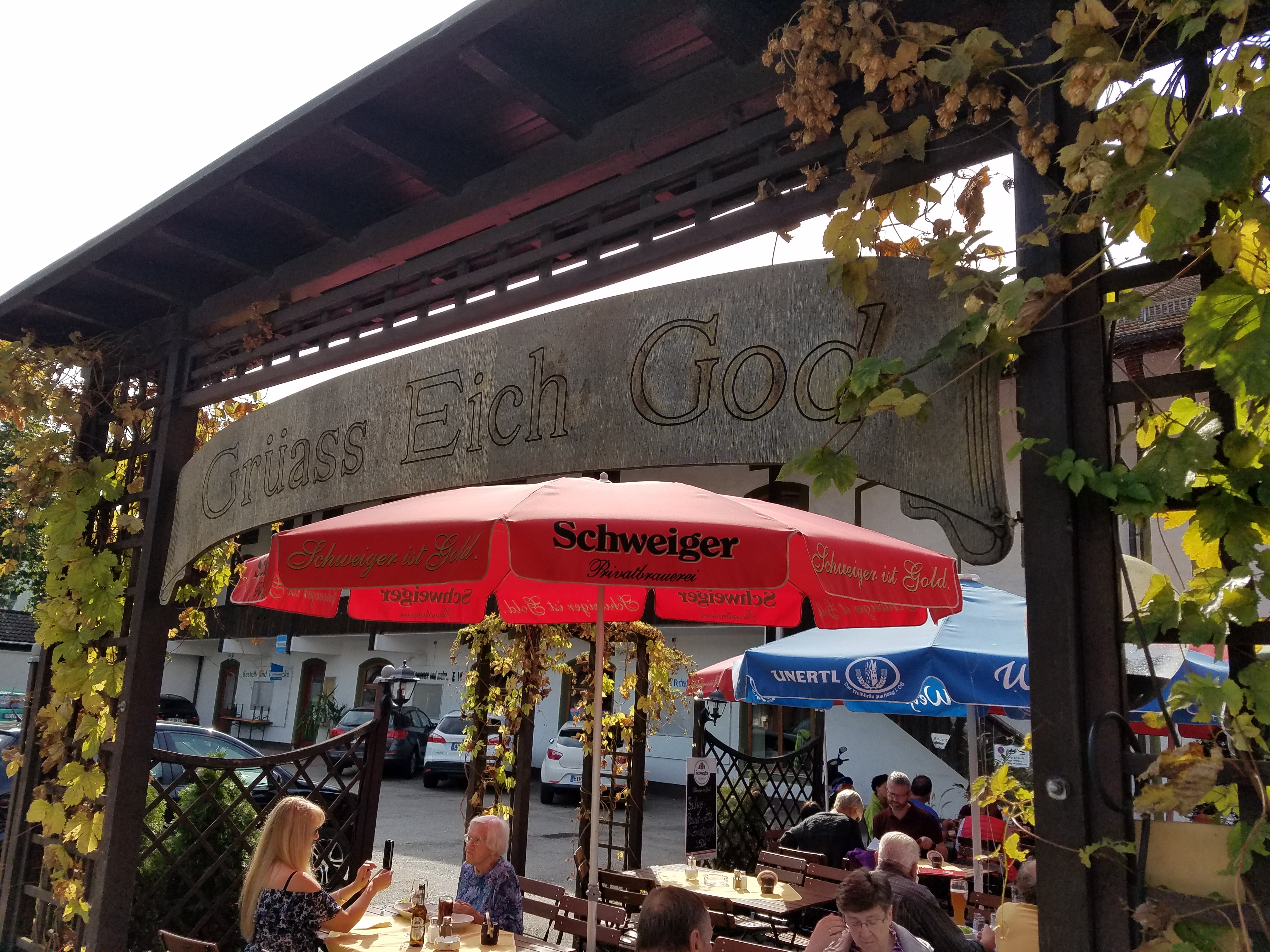 Beer Garden in Austria with "Grüass Eich God" sign - Gamesforlanguage.com