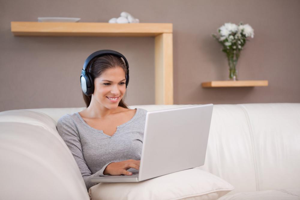 woman on laptop with earphone - Gamesforlanguage.com
