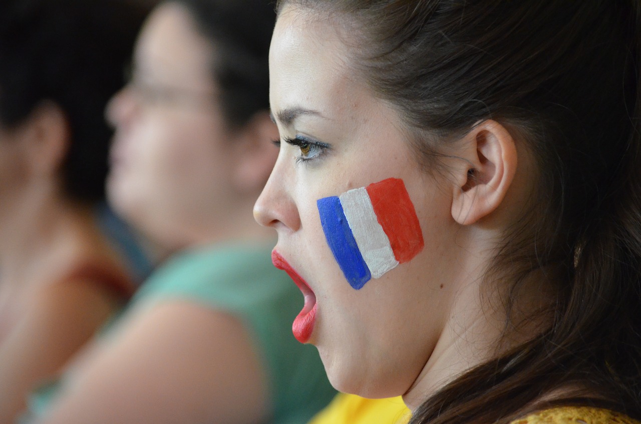 Girl, with French flag on cheek, shouting