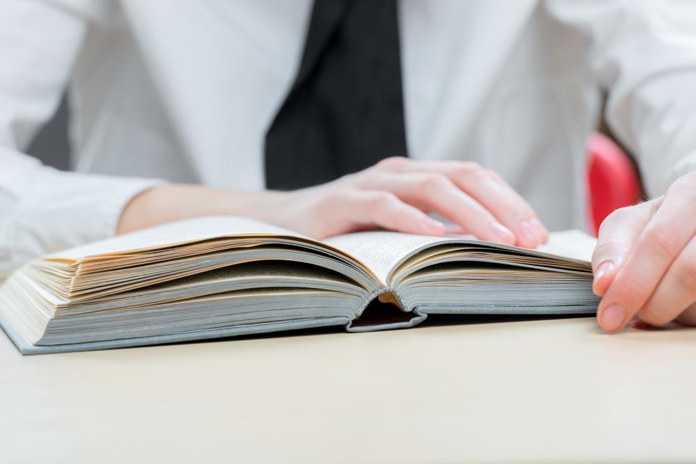 Grammar Book on table with woman's hands